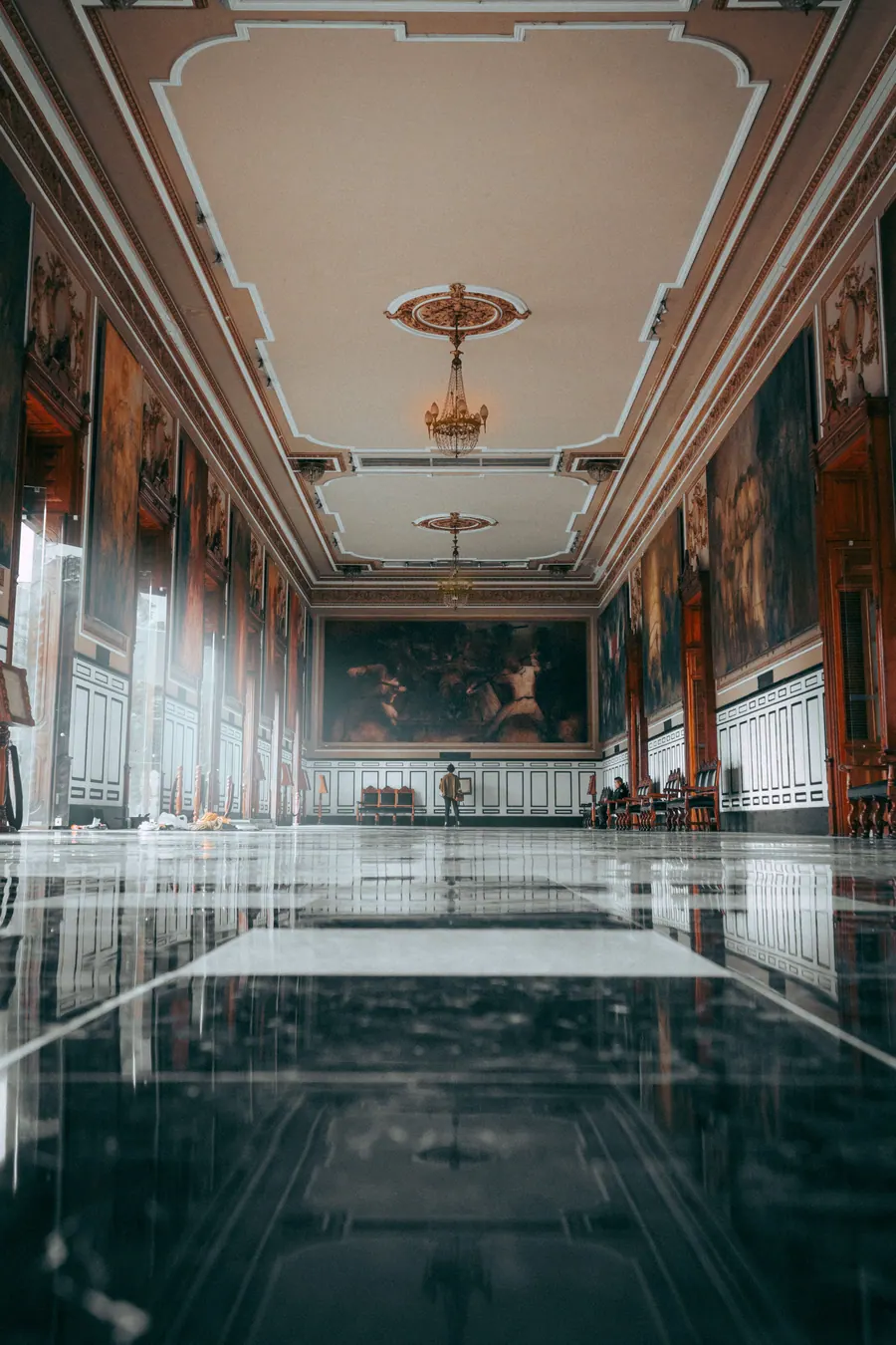 Long gallery hall displaying paintings